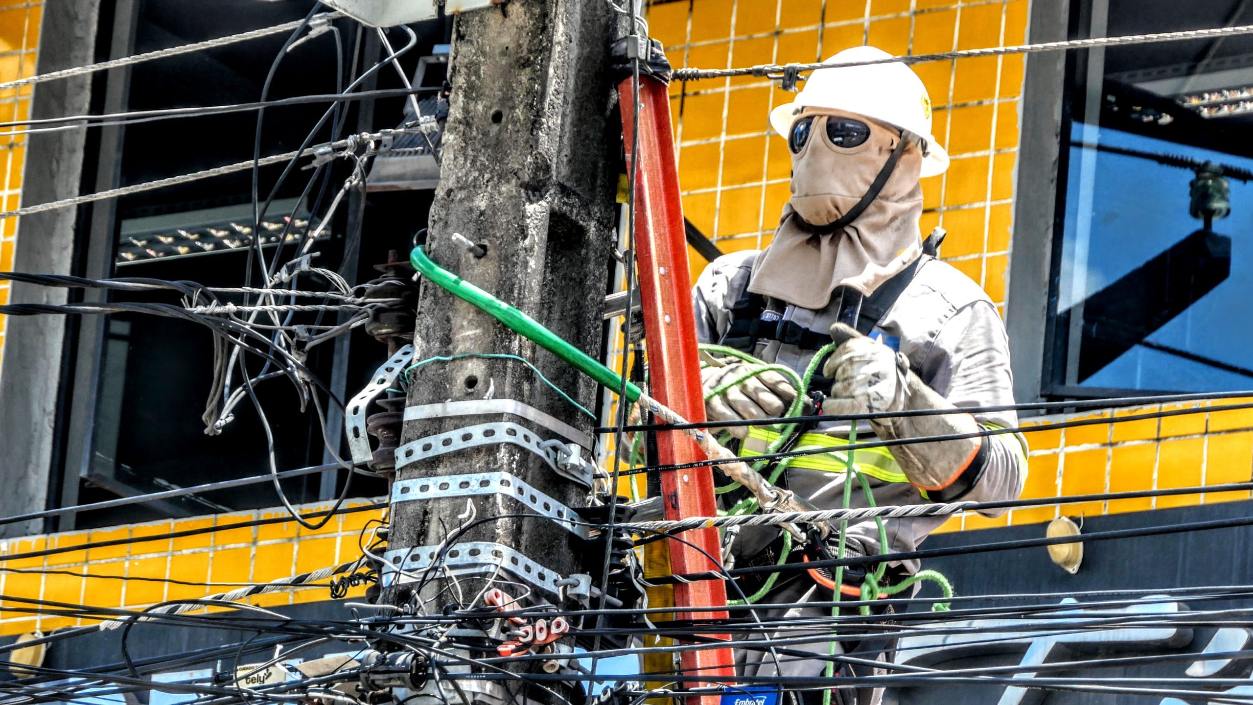 Beautiful shot of a man with Full body protection suit doing electrician power line tangle repair